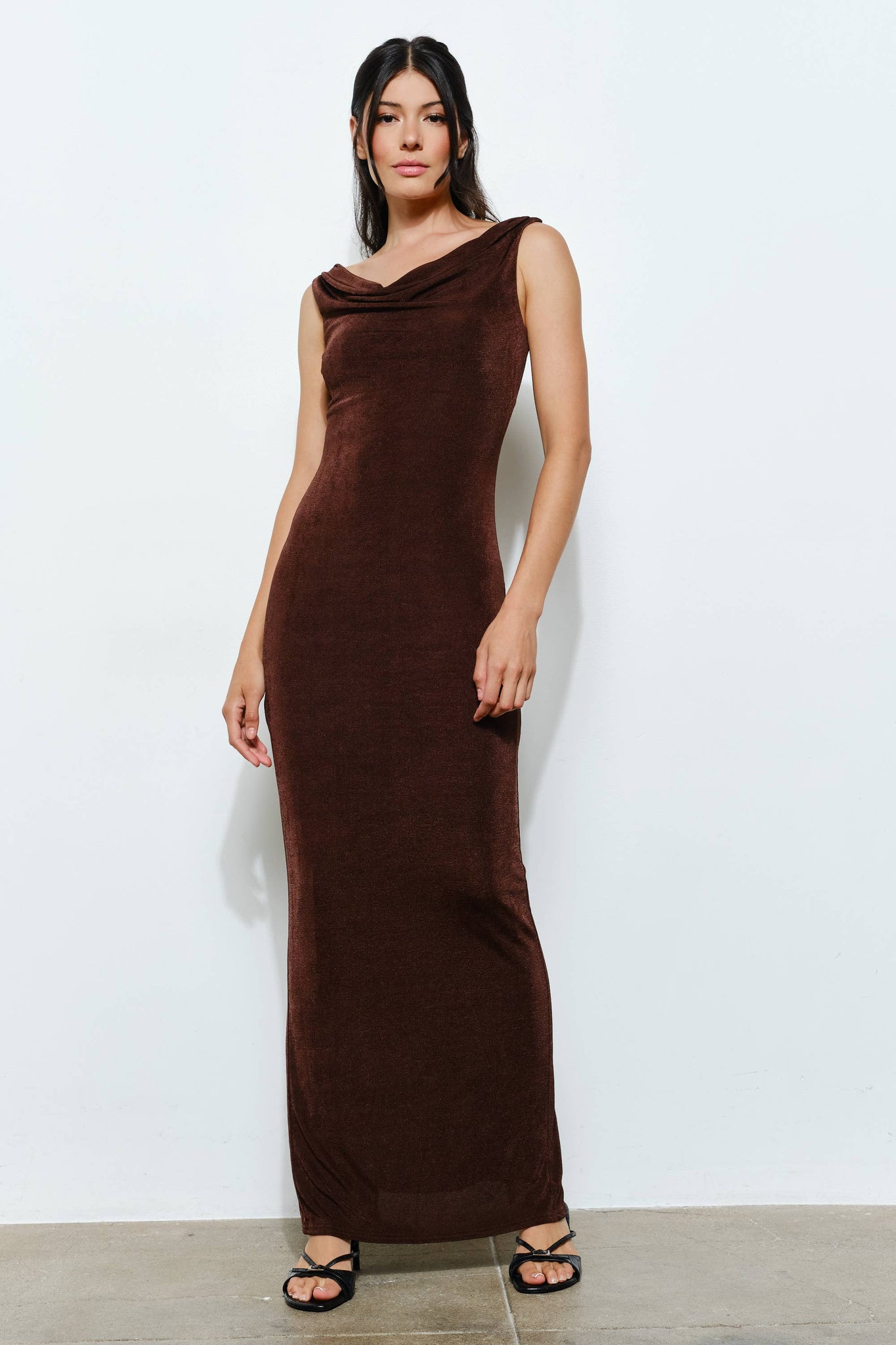 Woman wearing a brown sleeveless dress against a white background