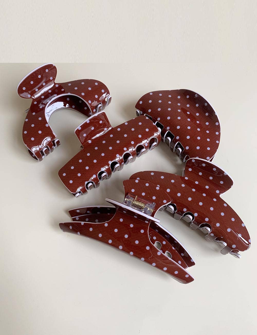 Set of red polka dot hair clips on a light beige background