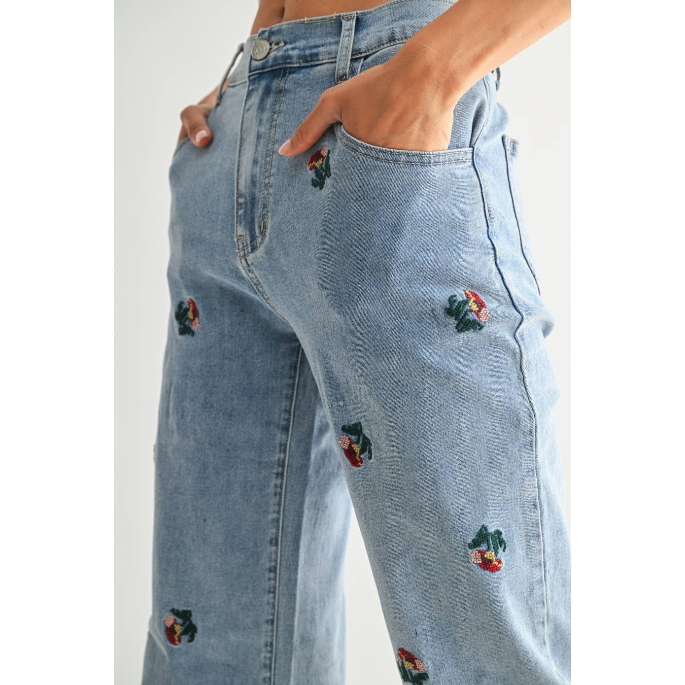 Light blue jeans with floral embroidery on a white background