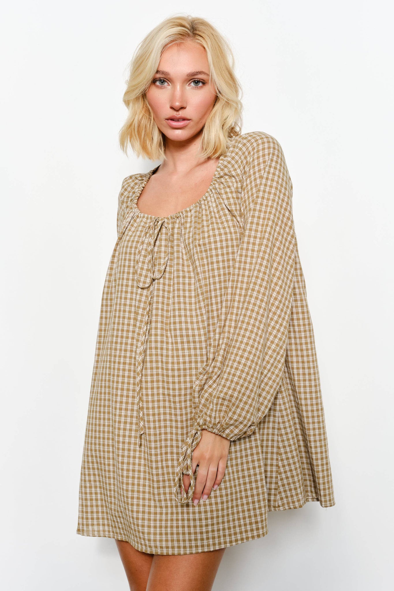 Woman wearing a checkered dress on a white background