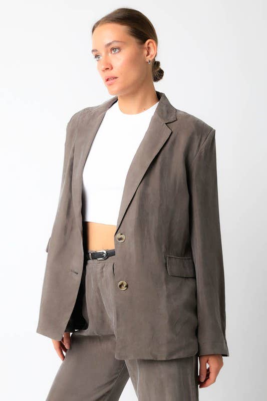 Woman wearing a gray suit with a white shirt on a white background